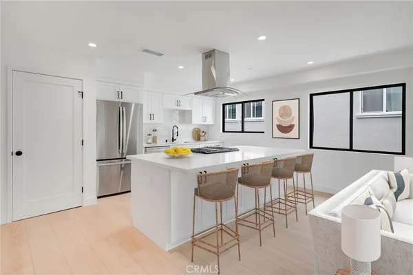 a kitchen with stainless steel appliances granite countertop a refrigerator and a stove top oven