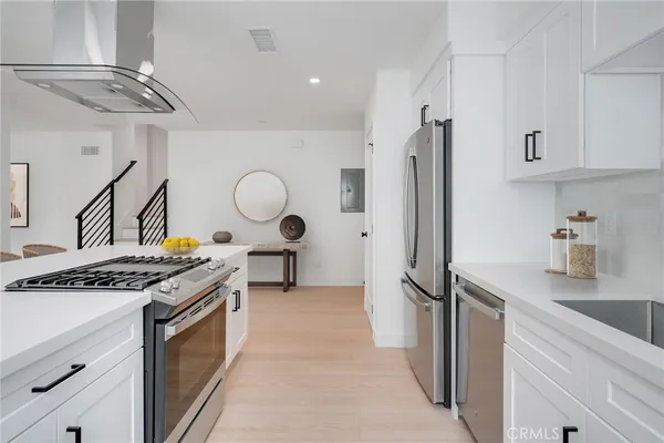 a kitchen with stainless steel appliances granite countertop a stove a refrigerator and a sink