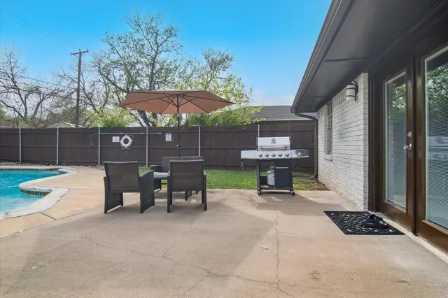 a view of a chairs and table in backyard of a house