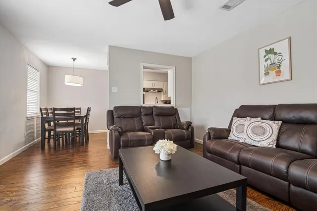a living room with furniture and wooden floor