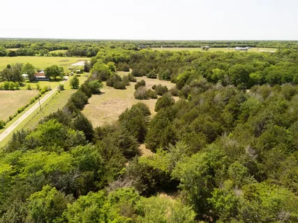 an aerial view of a houses with outdoor space and trees