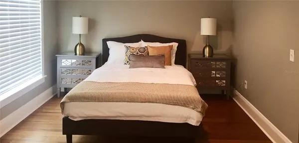 a large bed sitting in a bedroom next to a window