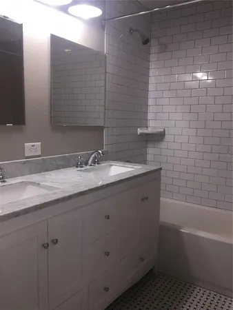 a bathroom with a granite countertop sink a toilet and shower