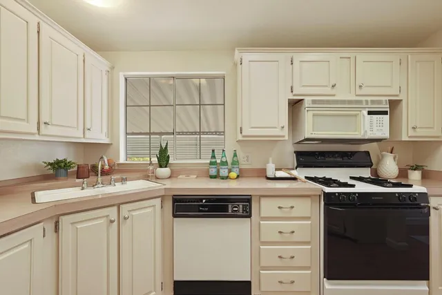 a kitchen with a stove cabinets and a refrigerator