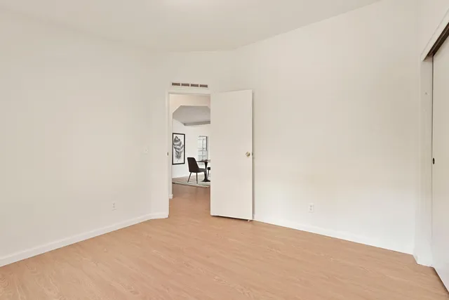 a spacious bedroom with a bed couch and a window