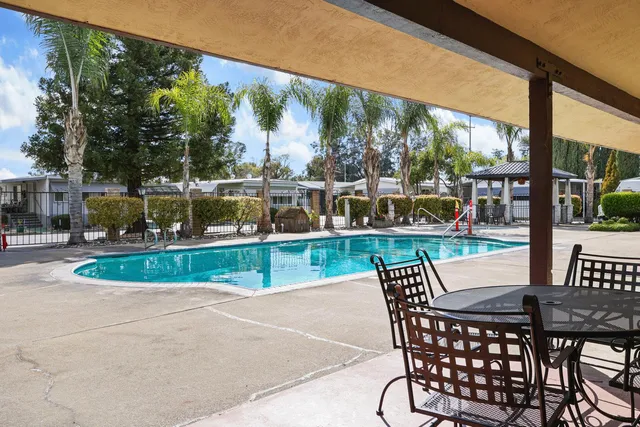 a living room with furniture a bookshelf and a window