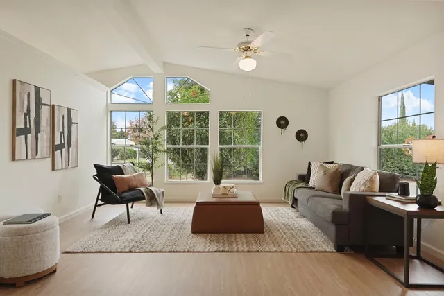 a living room with furniture fireplace and large windows