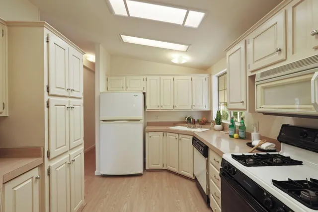 a kitchen with stainless steel appliances white cabinets and a window