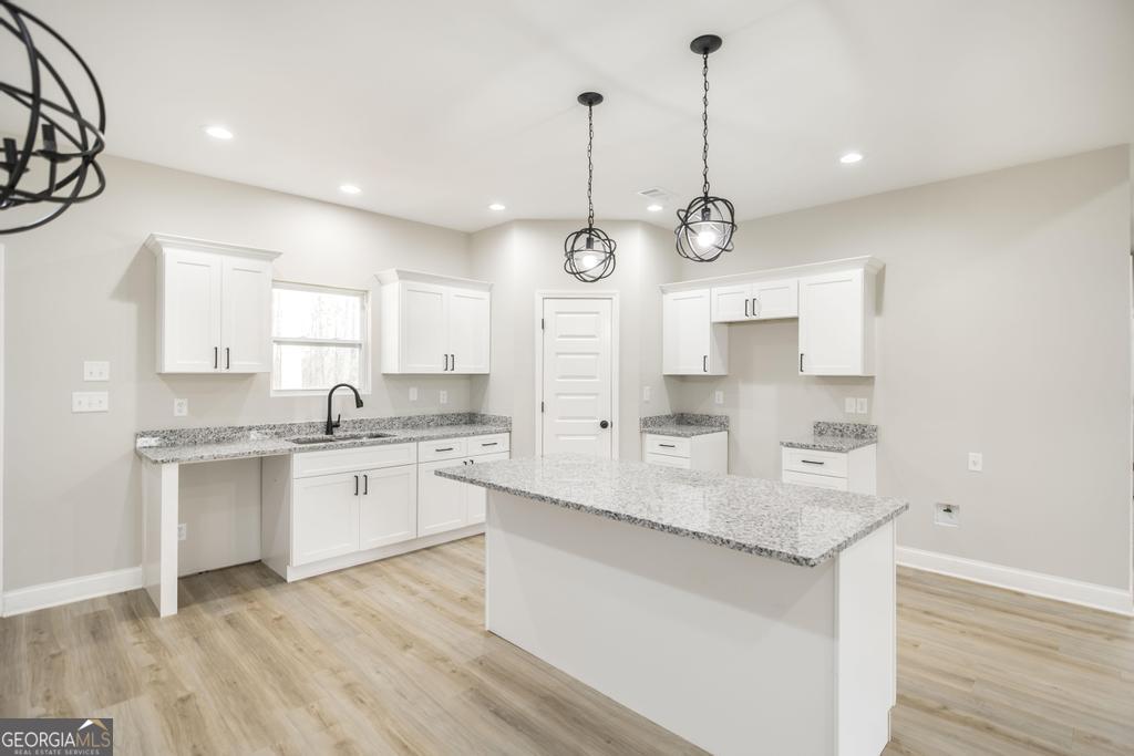 212 Lovett Farm Road East Dublin, GA 31027 - Photo 13 of 26 a kitchen with granite countertop a sink cabinets and wooden floor