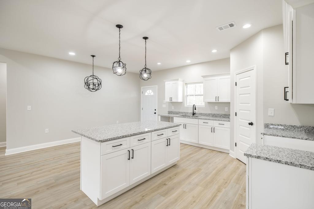 212 Lovett Farm Road East Dublin, GA 31027 - Photo 15 of 26 a large kitchen with stainless steel appliances kitchen island granite countertop a sink and cabinets