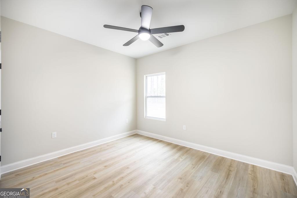 212 Lovett Farm Road East Dublin, GA 31027 - Photo 22 of 26 a view of a room with wooden floor and a ceiling fan