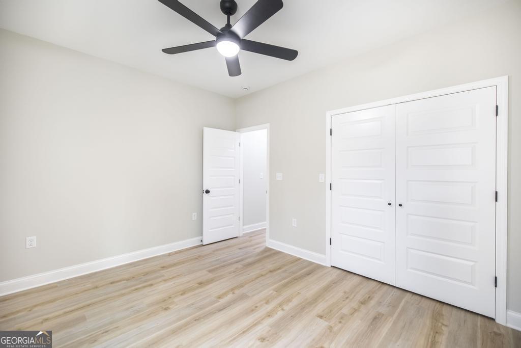 212 Lovett Farm Road East Dublin, GA 31027 - Photo 23 of 26 an empty room with wooden floor closet and ceiling fan