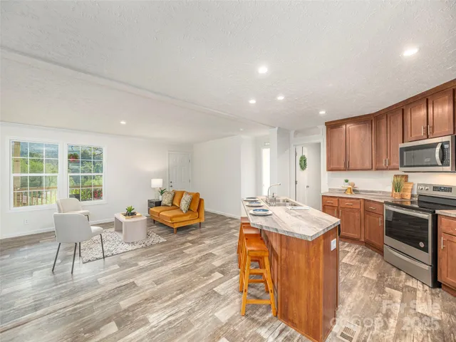 a kitchen with stainless steel appliances granite countertop a sink stove and refrigerator