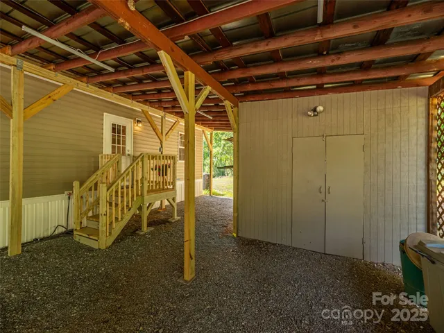 a backyard of a house with plants and large trees