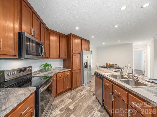 a kitchen with stainless steel appliances granite countertop a sink stove and refrigerator