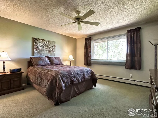a bedroom with a bed and a flat tv screen on the dresser