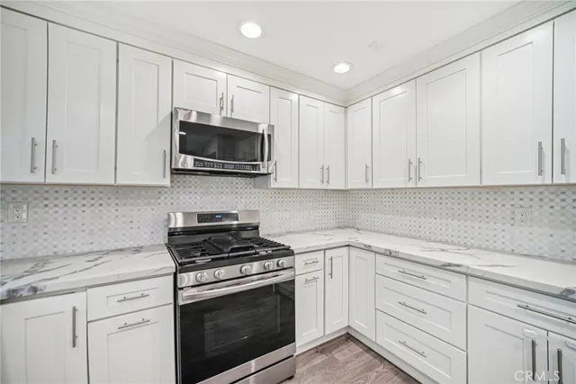 a kitchen with white cabinets and stainless steel appliances