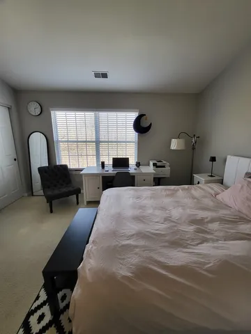 a bedroom with furniture and a large window