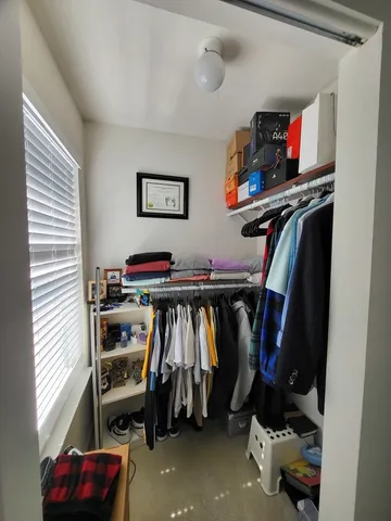 a view of walk in closet with clothes and shoes