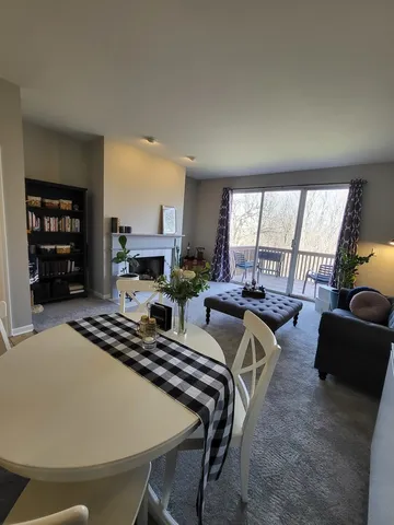 a living room with furniture a fireplace and a large window