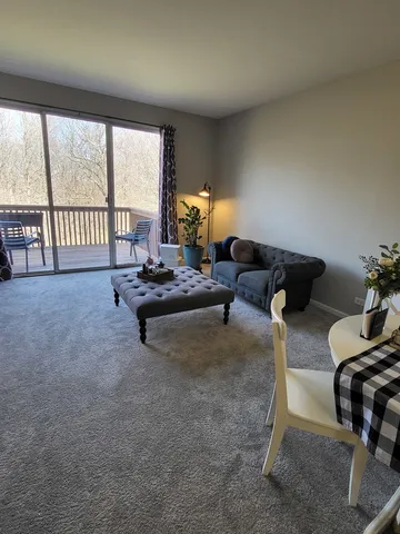 a living room with furniture and a floor to ceiling window