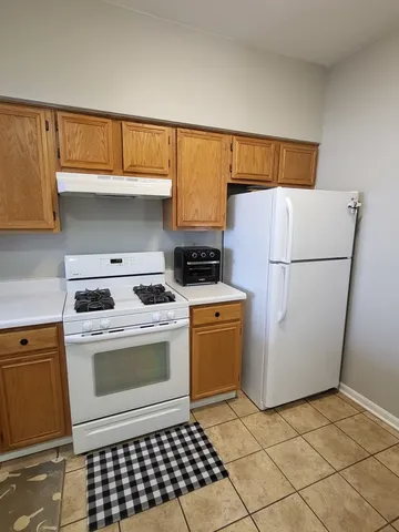 a kitchen with a stove a refrigerator and cabinets