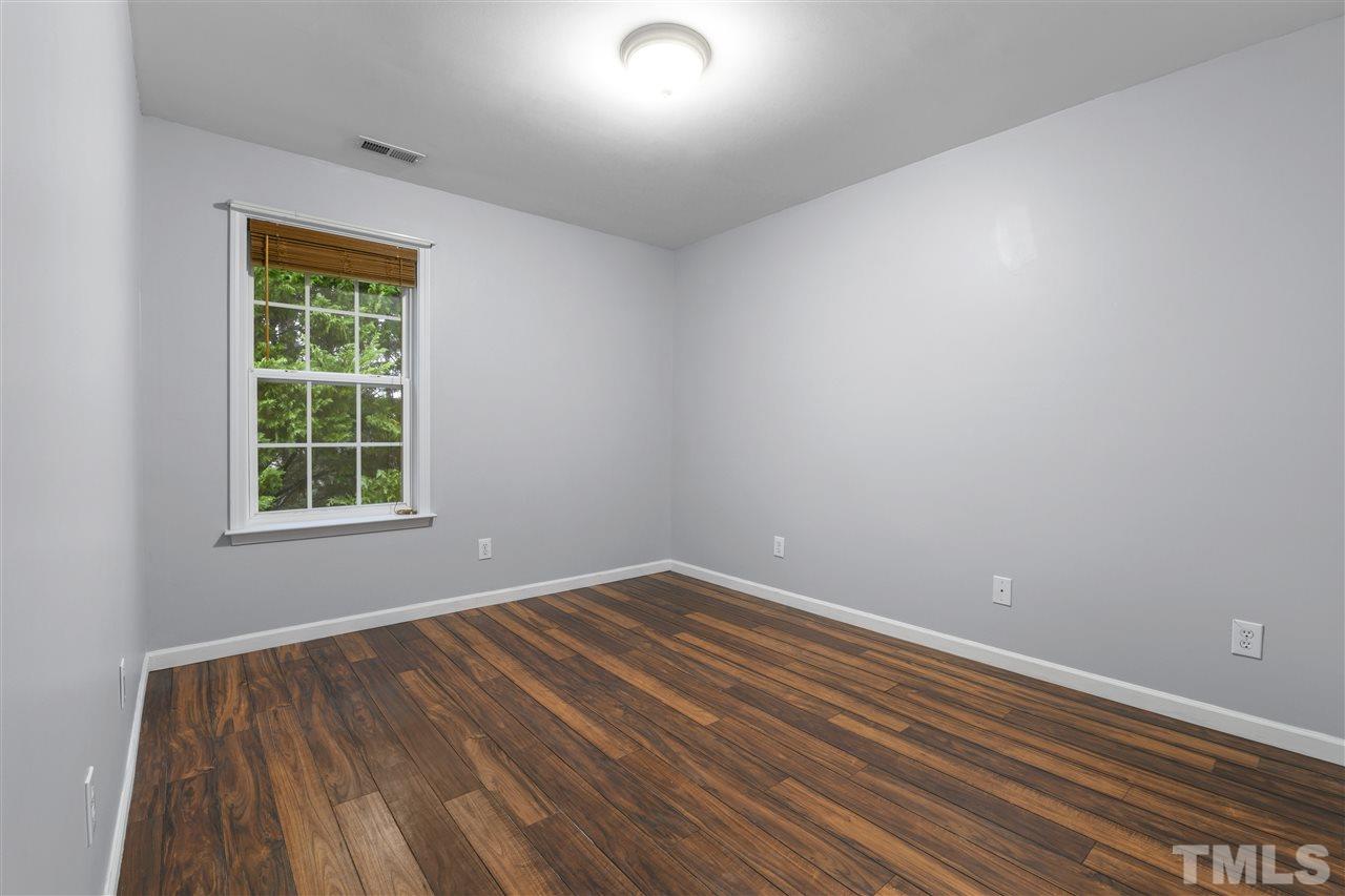 8235 Martello Lane Raleigh, NC 27613 - Photo 11 of 14 a view of an empty room with wooden floor and a window
