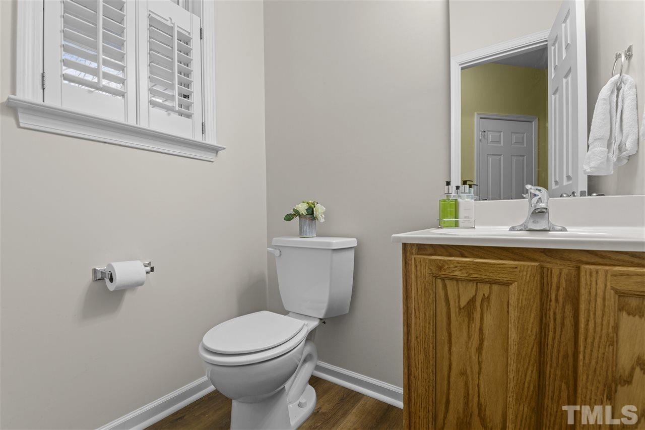 8235 Martello Lane Raleigh, NC 27613 - Photo 7 of 14 a bathroom with a granite countertop toilet sink and mirror