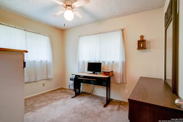 a view of a workspace with furniture and a window