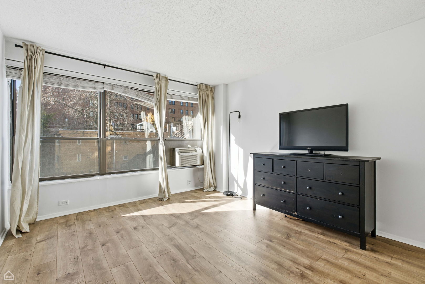 2930 North Sheridan Road, Unit 302 Chicago, IL 60657 - Photo 9 of 14 a living room with flat screen tv and floor to ceiling window