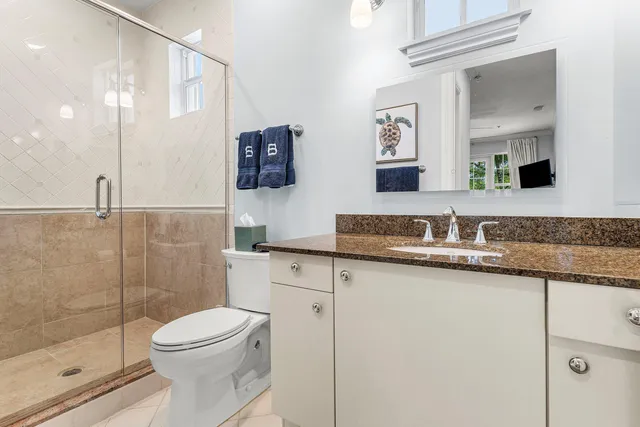 a bathroom with a granite countertop sink toilet and shower