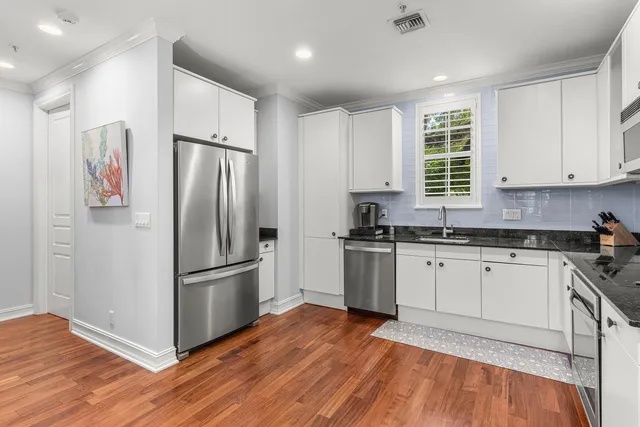 a kitchen with granite countertop a refrigerator and a sink