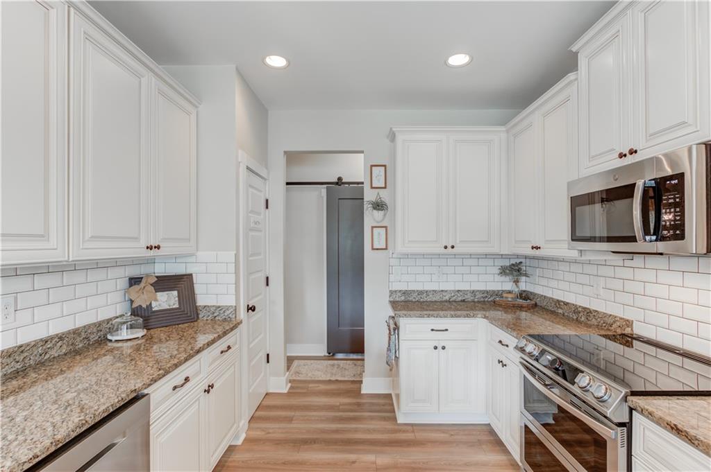 612 Quail Court Good Hope, GA 30641 - Photo 14 of 40 a kitchen with granite countertop a sink stove and refrigerator