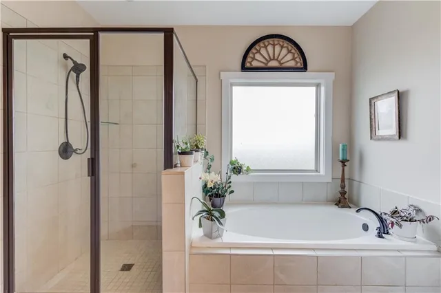 a bathroom with a bathtub a shower and a sink
