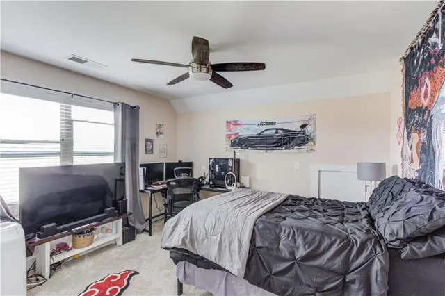 a bedroom with a bed and a flat tv screen on the dresser