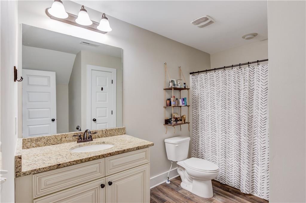 612 Quail Court Good Hope, GA 30641 - Photo 30 of 40 a bathroom with a granite countertop sink a toilet and a mirror