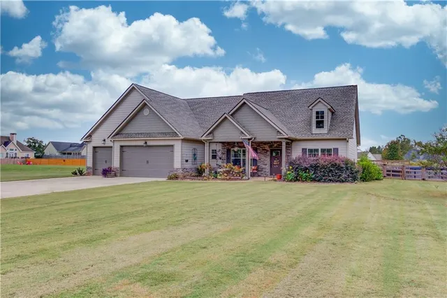 a front view of house with yard and trees in the background