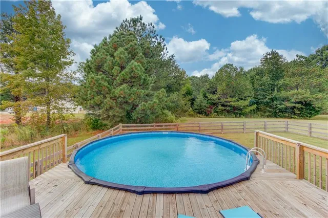 a view of a swimming pool with a patio and wooden floor