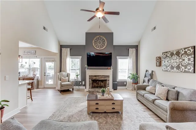 a living room with furniture a fireplace and a chandelier