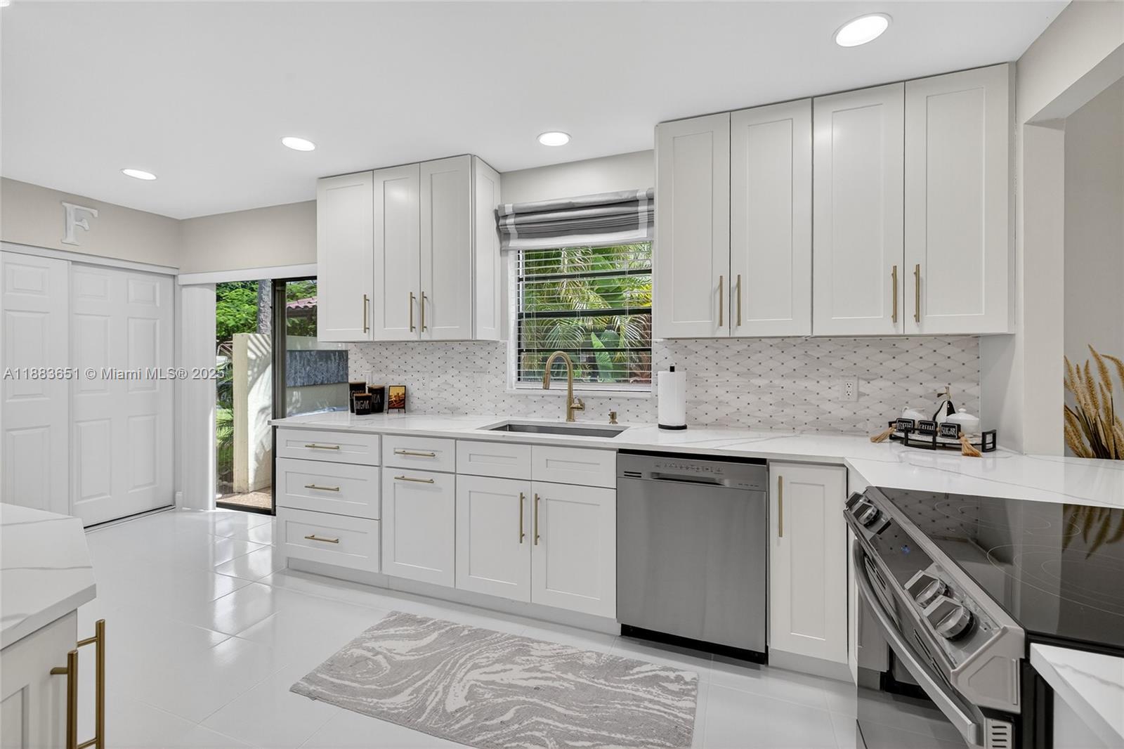 21695 Arriba Real Boca Raton, FL 33433 - Photo 16 of 61 a kitchen with a sink stove and cabinets