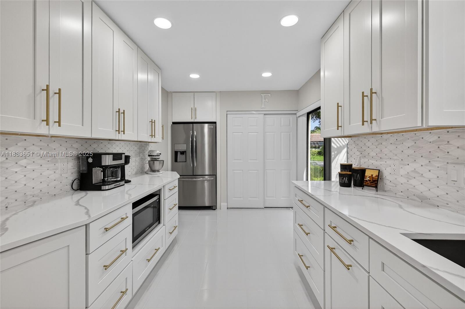 21695 Arriba Real Boca Raton, FL 33433 - Photo 9 of 61 a kitchen with white cabinets and stainless steel appliances