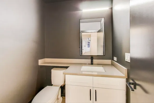 a bathroom with a toilet sink and mirror