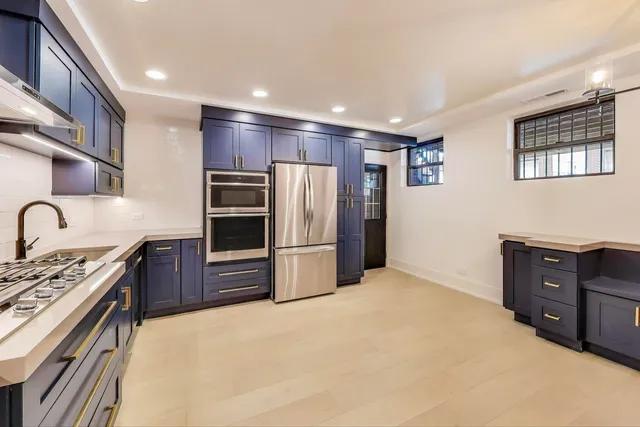 a kitchen with stainless steel appliances granite countertop a refrigerator and a stove top oven