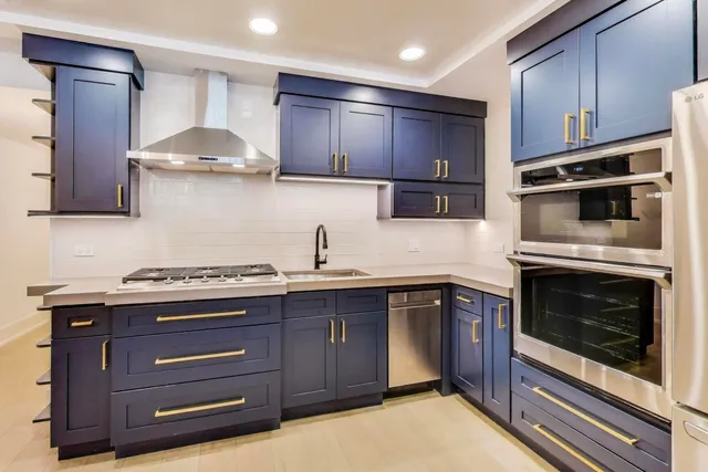 a kitchen with stainless steel appliances granite countertop a stove a microwave and oven