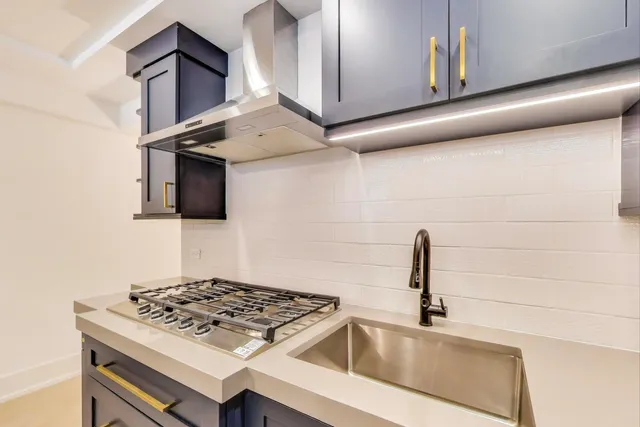 a kitchen with stainless steel appliances granite countertop a sink stove and microwave