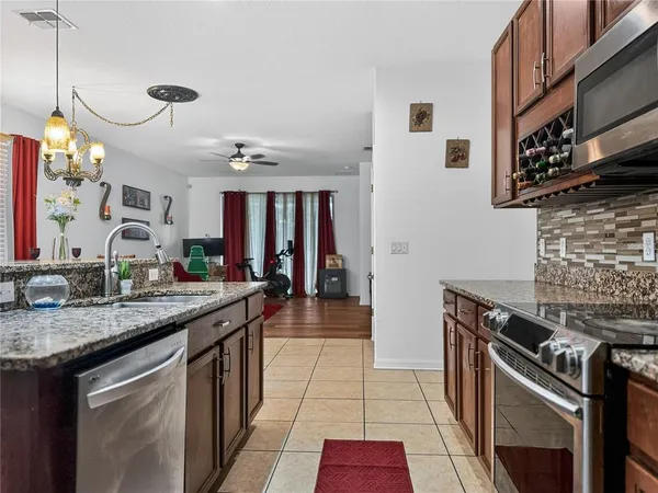 a kitchen with stainless steel appliances granite countertop a stove a sink and a microwave