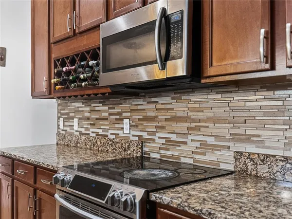 a kitchen with granite countertop a stove and a microwave
