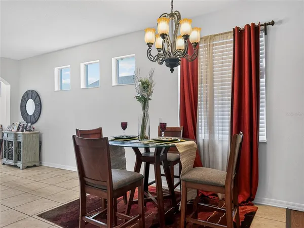 a view of a dining room with furniture a chandelier and wooden floor