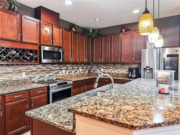 a kitchen with stainless steel appliances granite countertop a sink stove and refrigerator