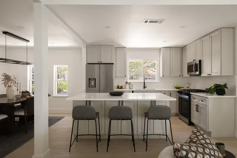a kitchen with a table chairs refrigerator and microwave